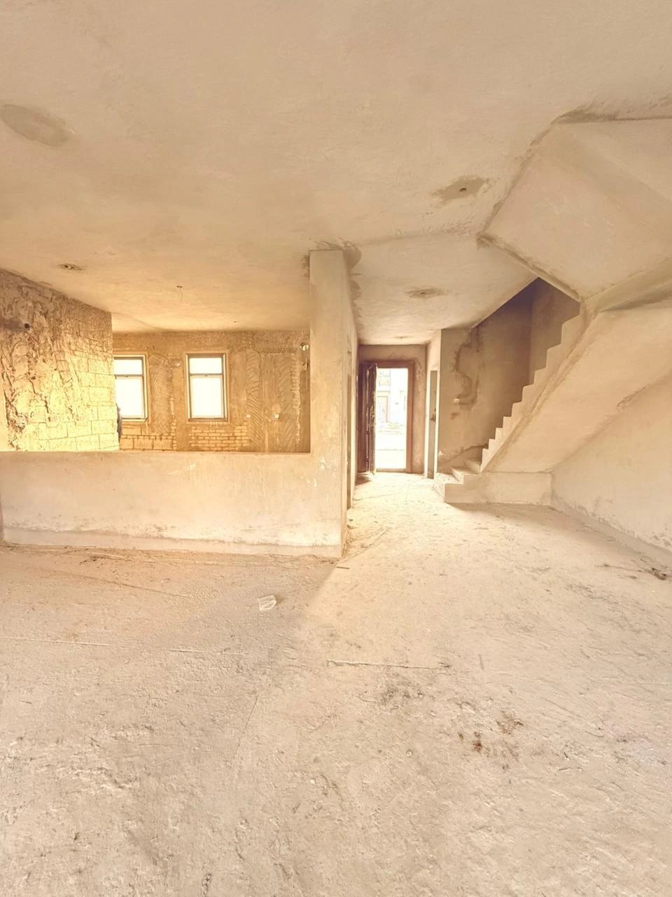 Unfinished staircase and ground-floor corridor inside the SODIC VYE townhouse